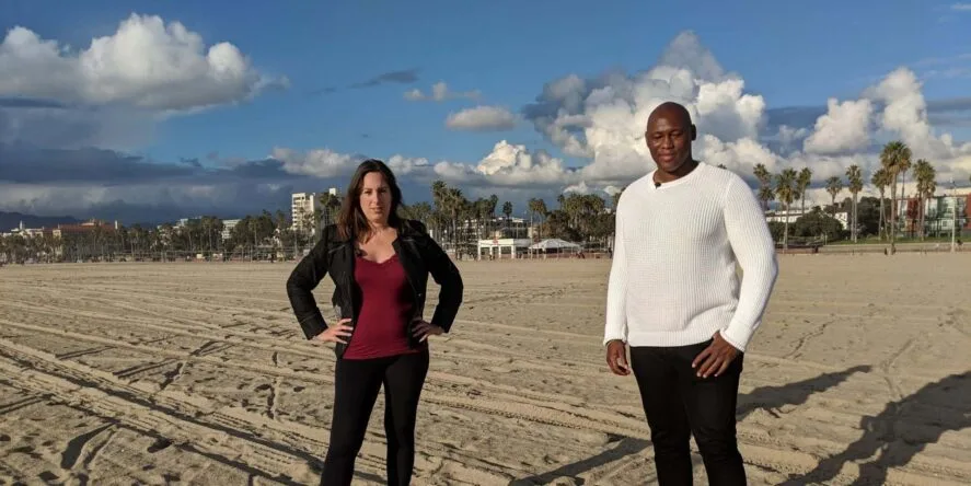 a man and woman standing on a beach